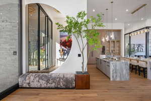 Interior space featuring light stone counters, light wood-style flooring, modern cabinets, and a breakfast bar