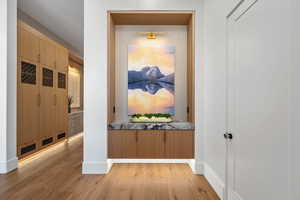 Corridor featuring light wood-style flooring and baseboards