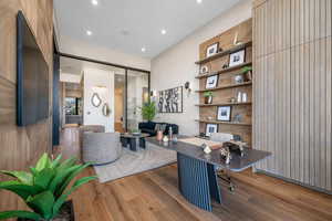 Office with wood-type flooring and recessed lighting