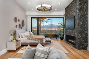 Bedroom featuring light wood finished floors, a fireplace, and access to exterior