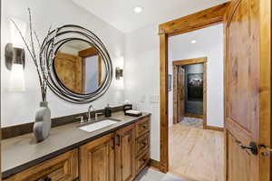 Bathroom with recessed lighting, light wood finished floors, and vanity