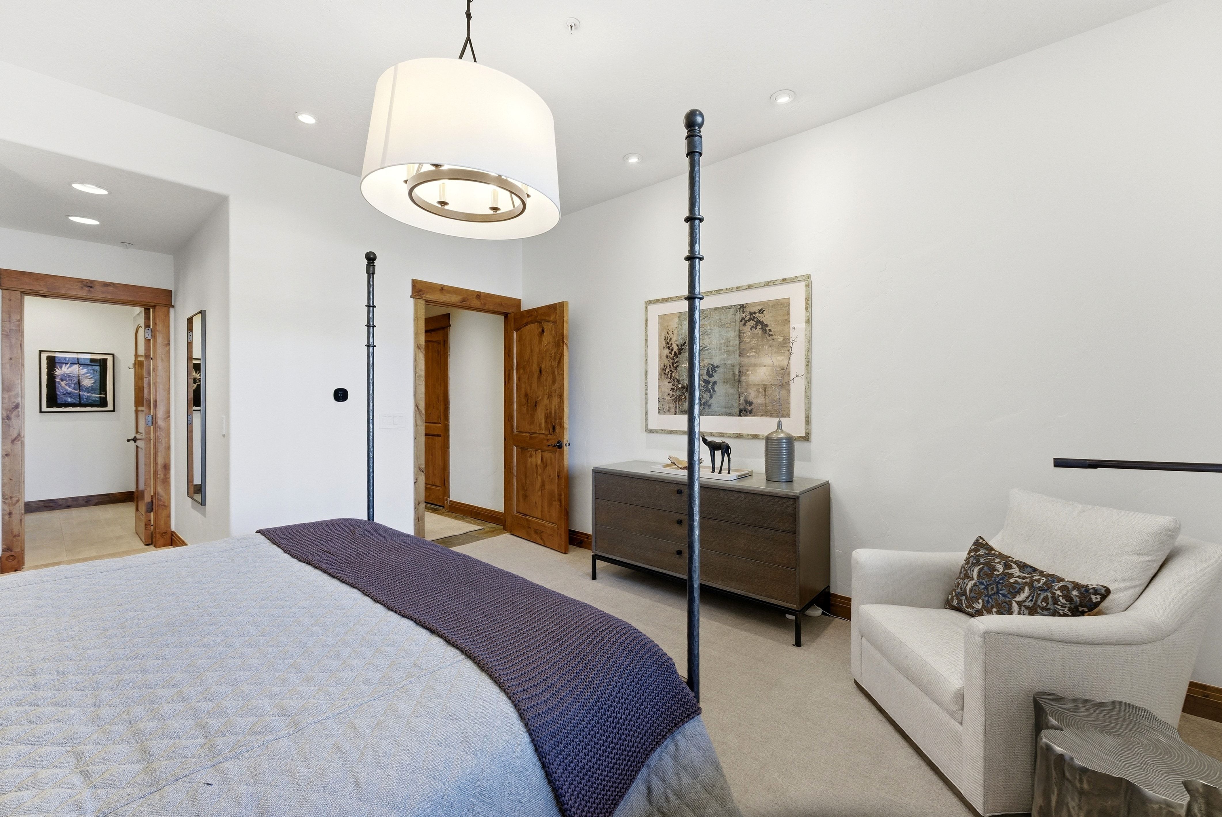 Spacious room featuring wood-finish door frames, recessed lighting, a ceiling-mounted drum pendant, and light-toned carpeting