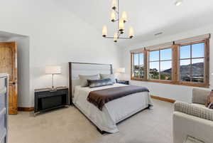 Bedroom with a mountain view, light colored carpet, and lofted ceiling