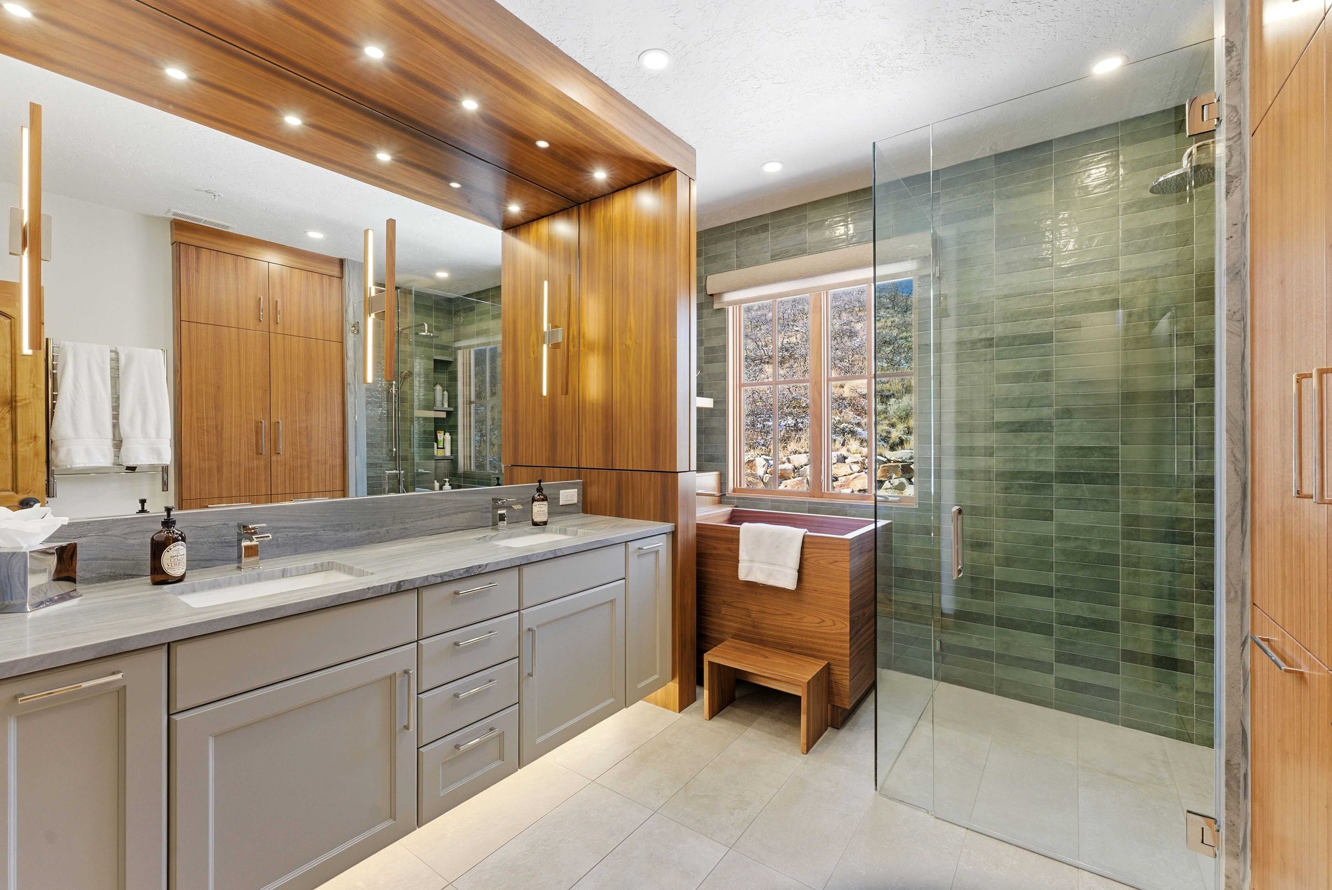 Bathroom featuring a dual vanity with light grey cabinetry, integrated sinks, and a stone countertop