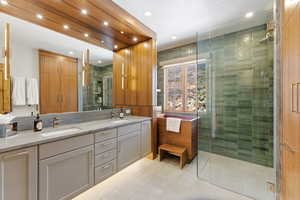 Full bath with double vanity, a shower stall, light tile patterned flooring, and recessed lighting