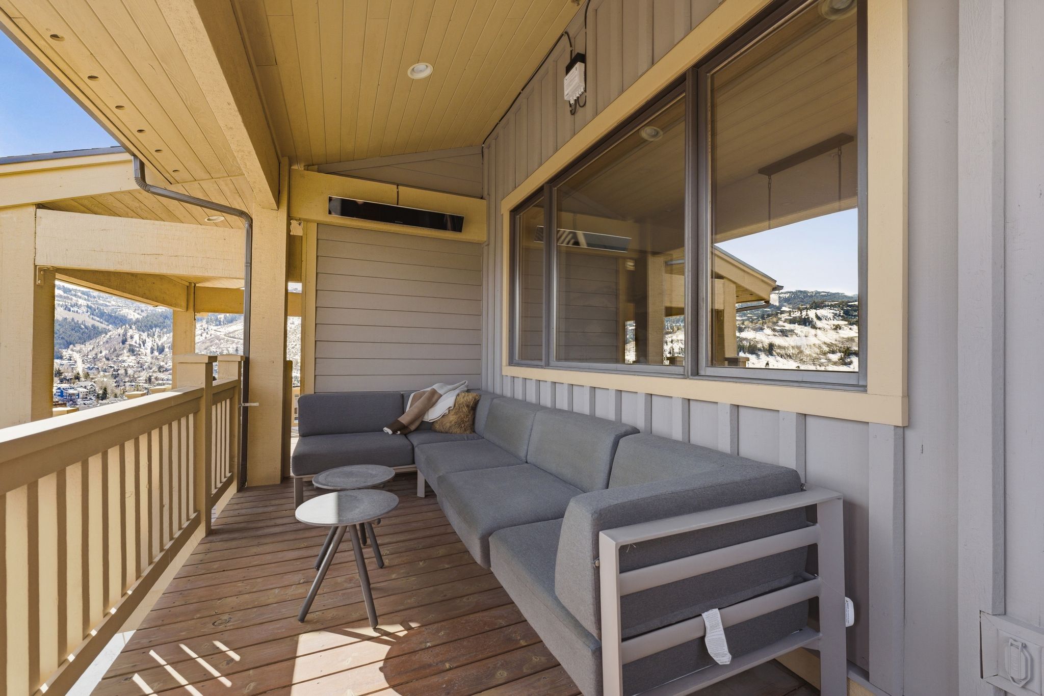 Covered outdoor deck with wood-finish flooring and railing