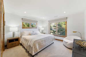 Carpeted bedroom with multiple windows and recessed lighting