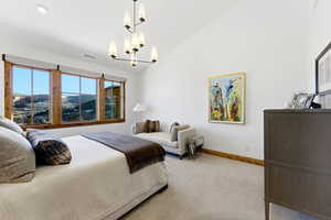 Carpeted bedroom with lofted ceiling, a mountain view, and a chandelier