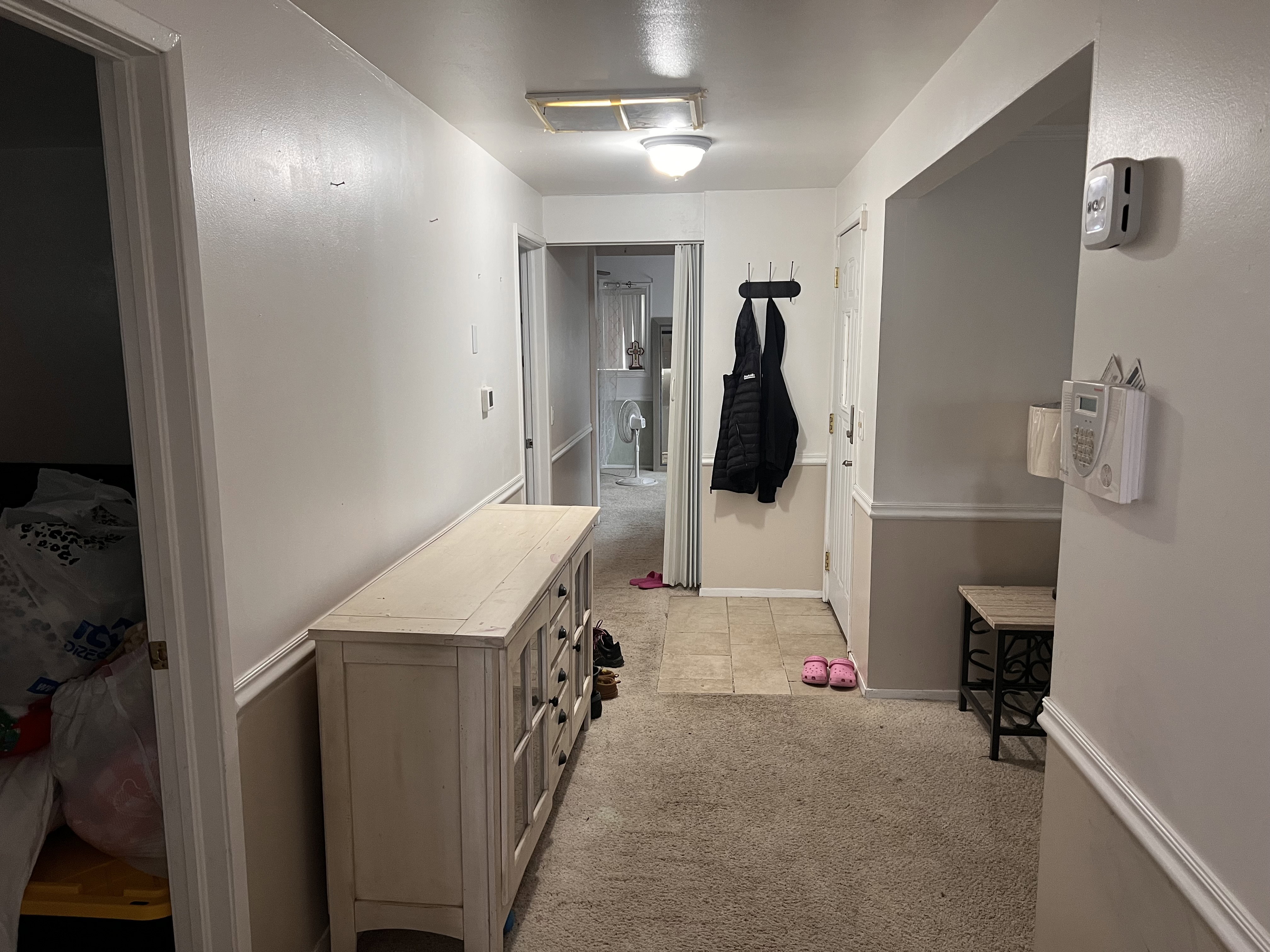 Corridor with light colored carpet and baseboards