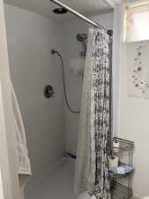 Bathroom featuring curtained shower and a textured ceiling