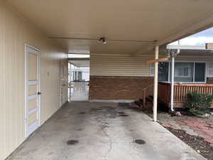 Covered porch featuring a gate and a carport