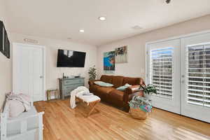 Living area with french doors, light wood-style flooring, and recessed lighting
