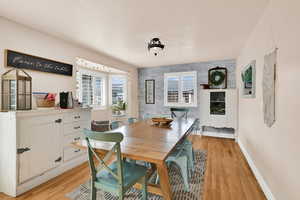 Dining space with an accent wall and light wood-style floors