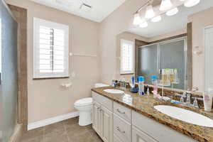 Bathroom with a stall shower, double vanity, and light tile patterned flooring