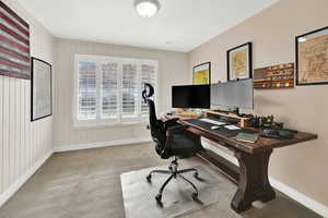 Home office featuring light colored carpet and baseboards