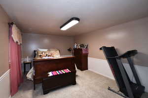Bedroom featuring light carpet and baseboards