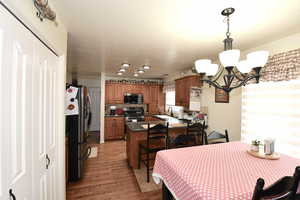 Dining room with suspended lighting and light wood finished floors