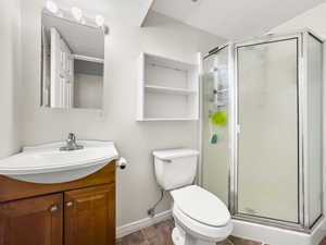 Bathroom featuring vanity, a shower stall, a textured ceiling, and tile patterned flooring