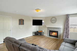 Living room with wood finished floors and a fireplace