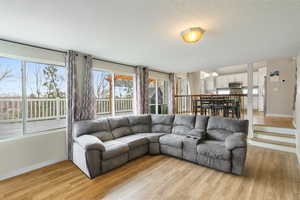 Living room featuring light wood-style floors and a textured ceiling