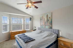 Bedroom with lofted ceiling, carpet floors, and a ceiling fan