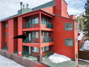 Snow covered property with a view of apartment building / complex