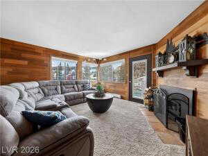 Living room featuring wood walls and a fireplace with flush hearth
