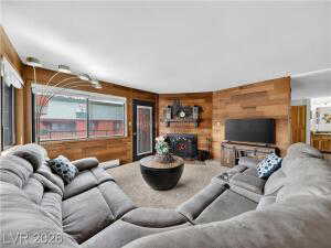 Living area with wooden walls, a fireplace, and carpet
