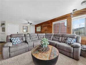 Living room featuring wooden walls and ceiling fan