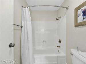 Bathroom featuring toilet and shower / tub combo