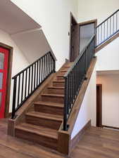 Staircase featuring a high ceiling and wood finished floors