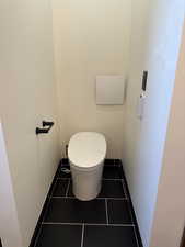 Bathroom with toilet and dark tile patterned flooring
