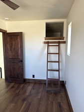Unfurnished bedroom featuring dark wood finished floors, a textured ceiling, and a ceiling fan