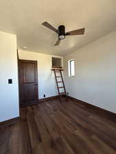 Unfurnished bedroom with dark wood-style floors, a textured ceiling, ceiling fan, and a closet