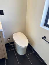 Bathroom with dark tile patterned flooring and vanity