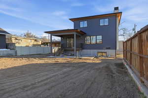 Rear view of property with a chimney and a patio