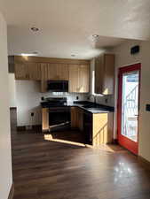 Kitchen with dark countertops, electric range oven, dark wood-style floors, and recessed lighting
