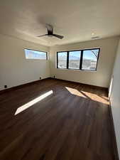 Unfurnished room featuring dark wood-style floors and a ceiling fan