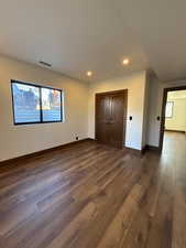 Unfurnished bedroom featuring dark wood finished floors, recessed lighting, and a closet