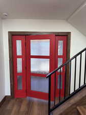 Foyer with stairs and dark wood-style flooring
