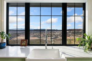 Kitchen view of a mountain backdrop and light stone countertops