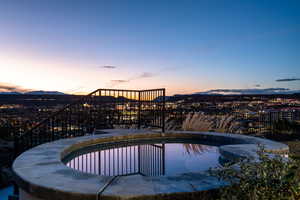 Pool at dusk featuring a patio, a swimming pool, and a mountain view