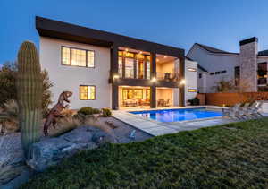 Rear view of property with a balcony, stucco siding, an outdoor pool, and a patio