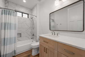Bathroom with vanity, shower / tub combo, dark wood-style floors, and recessed lighting