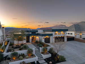 Contemporary house with stucco siding, a garage, concrete driveway, and a mountain view