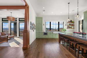 Kitchen with green cabinets, pendant lighting, and dark wood finished floors