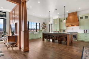 Dual tone kitchen featuring a kitchen island, high end stainless steel range oven, backsplash, dark wood finished floors, and dual tone cabinets