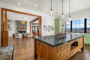 Kitchen with plenty of natural light, dark wood-style flooring, pendant lighting, and green cabinetry