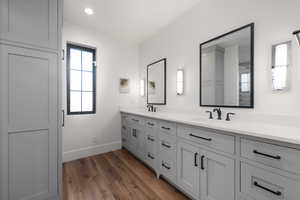 Full bathroom featuring double vanity, dark wood-style floors, and recessed lighting