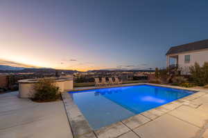 View of pool with patio surround, a fenced backyard, and a mountain view